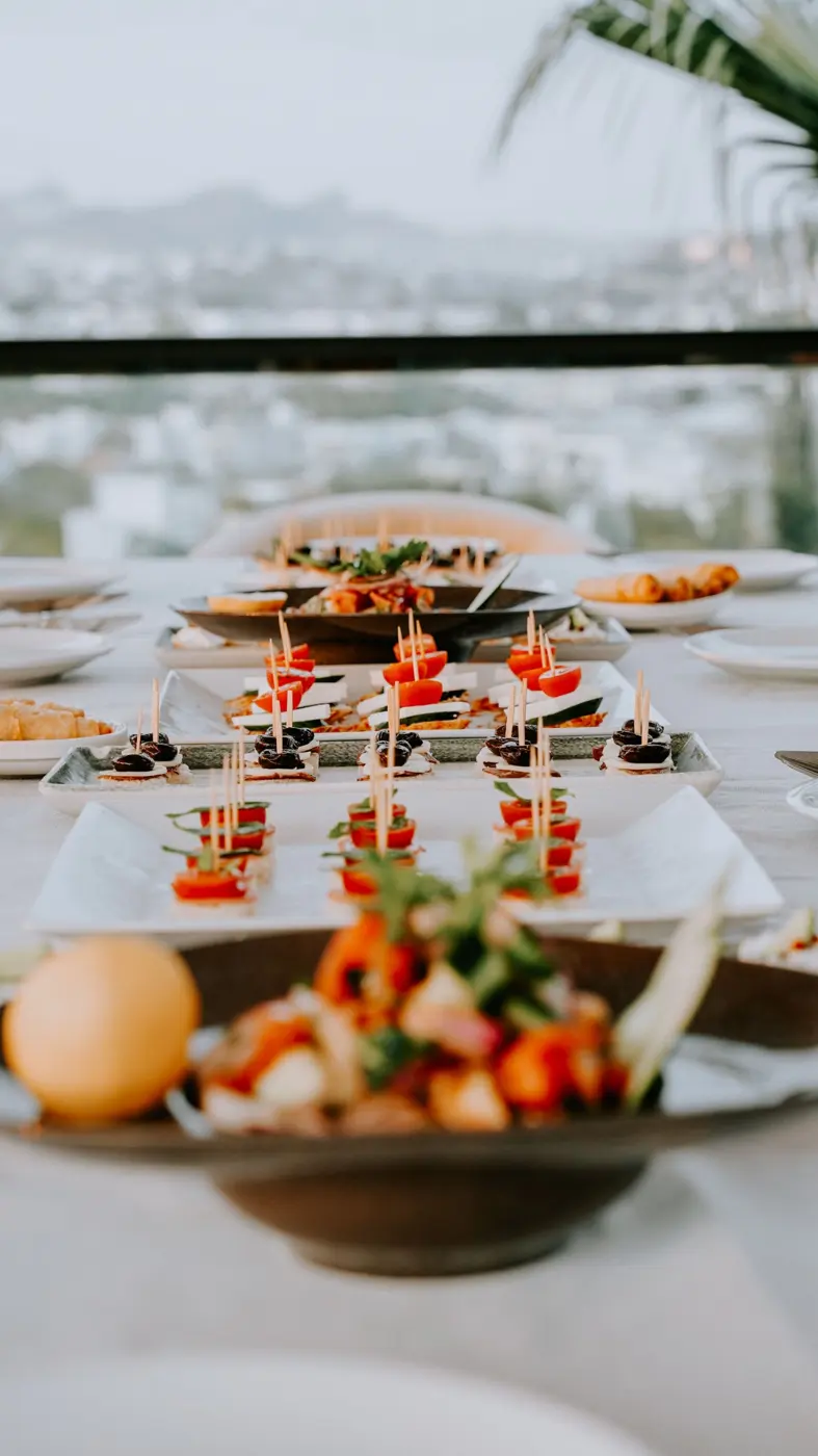 Small plates and skewers laid out on a terrace table with a city view